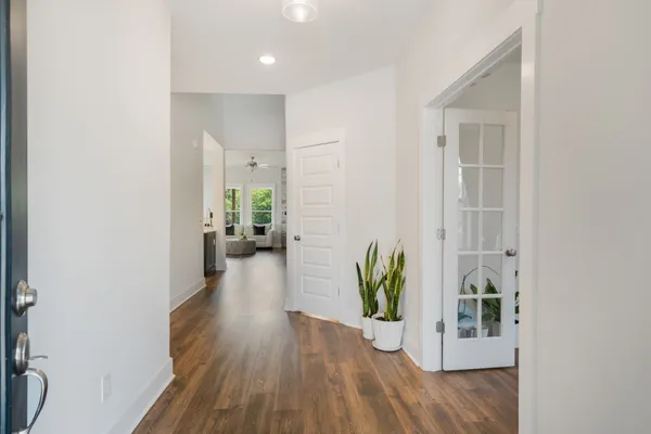 a view of a hallway with wooden floor and a potted plant