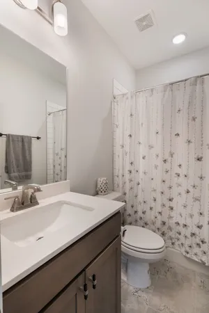 a bathroom with a sink a toilet and shower curtain