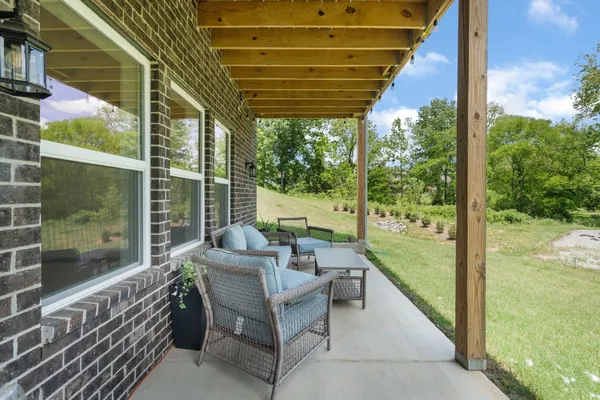 a view of a patio with couches chairs and wooden floor