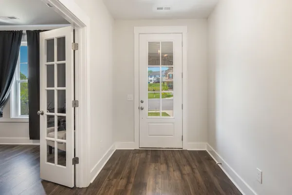 an empty room with wooden floor and windows