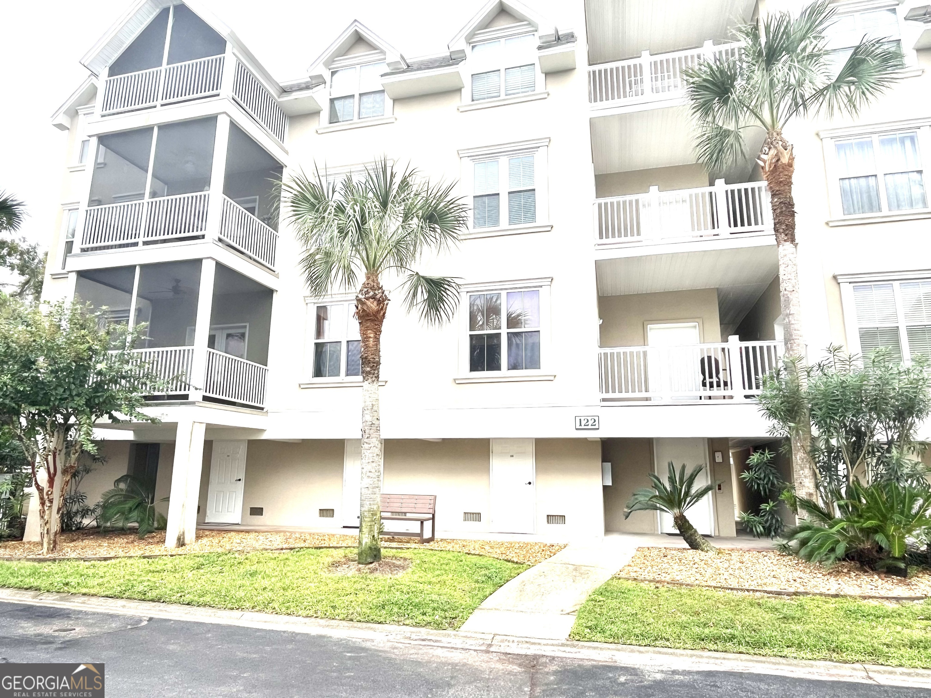 122 Shady Brook Circle, Unit 100 St. Simons, GA 31522 - Photo 1 of 39 a front view of a building with a garden and plants