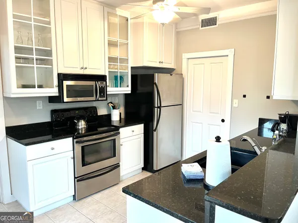 a kitchen with stainless steel appliances granite countertop a stove a refrigerator and a microwave