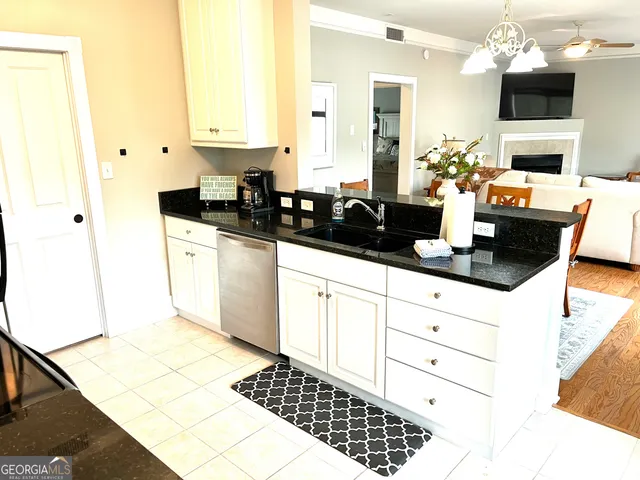 a kitchen with granite countertop a sink stove and cabinets