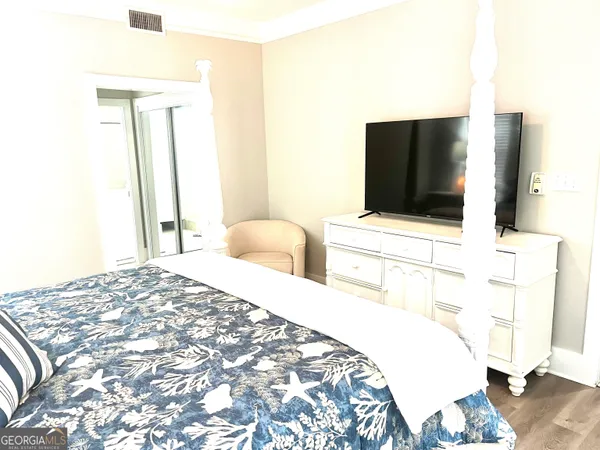 a bedroom with a bed and a flat screen tv