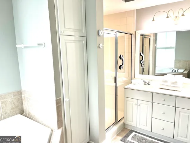 a bathroom with a granite countertop sink a mirror and a shower