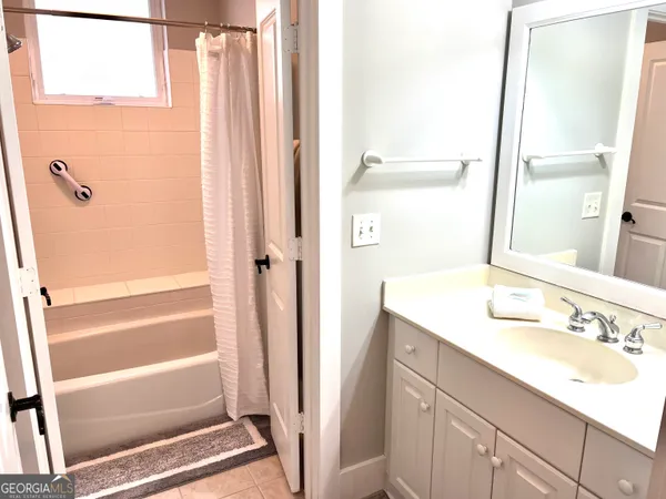 a bathroom with a granite countertop sink shower and a mirror
