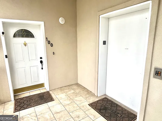 a view of a hallway with wooden floor and a bathroom