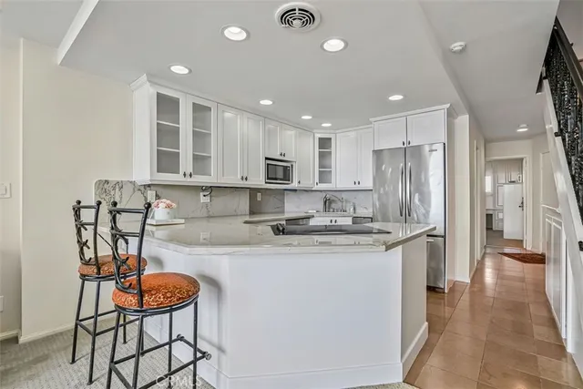 a kitchen with stainless steel appliances granite countertop a stove a sink a refrigerator and cabinets