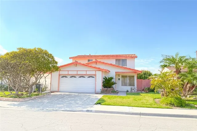 a front view of a house with a garden and garage
