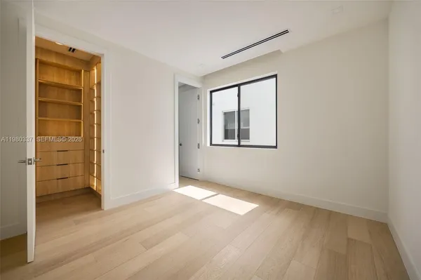 an empty room with a wooden door and a window