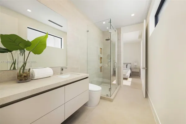 a bathroom with a double vanity sink toilet and shower