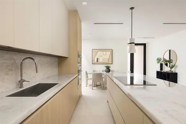 a large kitchen with granite countertop a sink a counter top space and cabinets