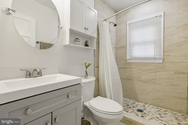 a bathroom with a sink a toilet and shower