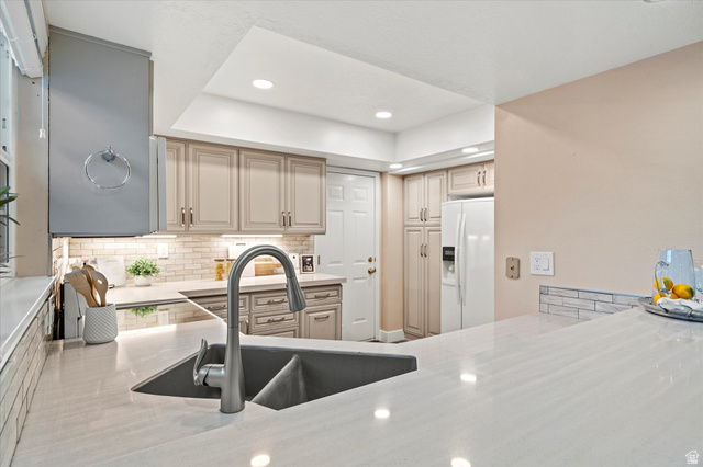 888 East 6895 South Midvale, UT 84047 - Photo 10 of 54 Bright kitchen with sleek solid-surface countertops, under-cabinet lighting, and ample cabinetry, offering both style and functionality.