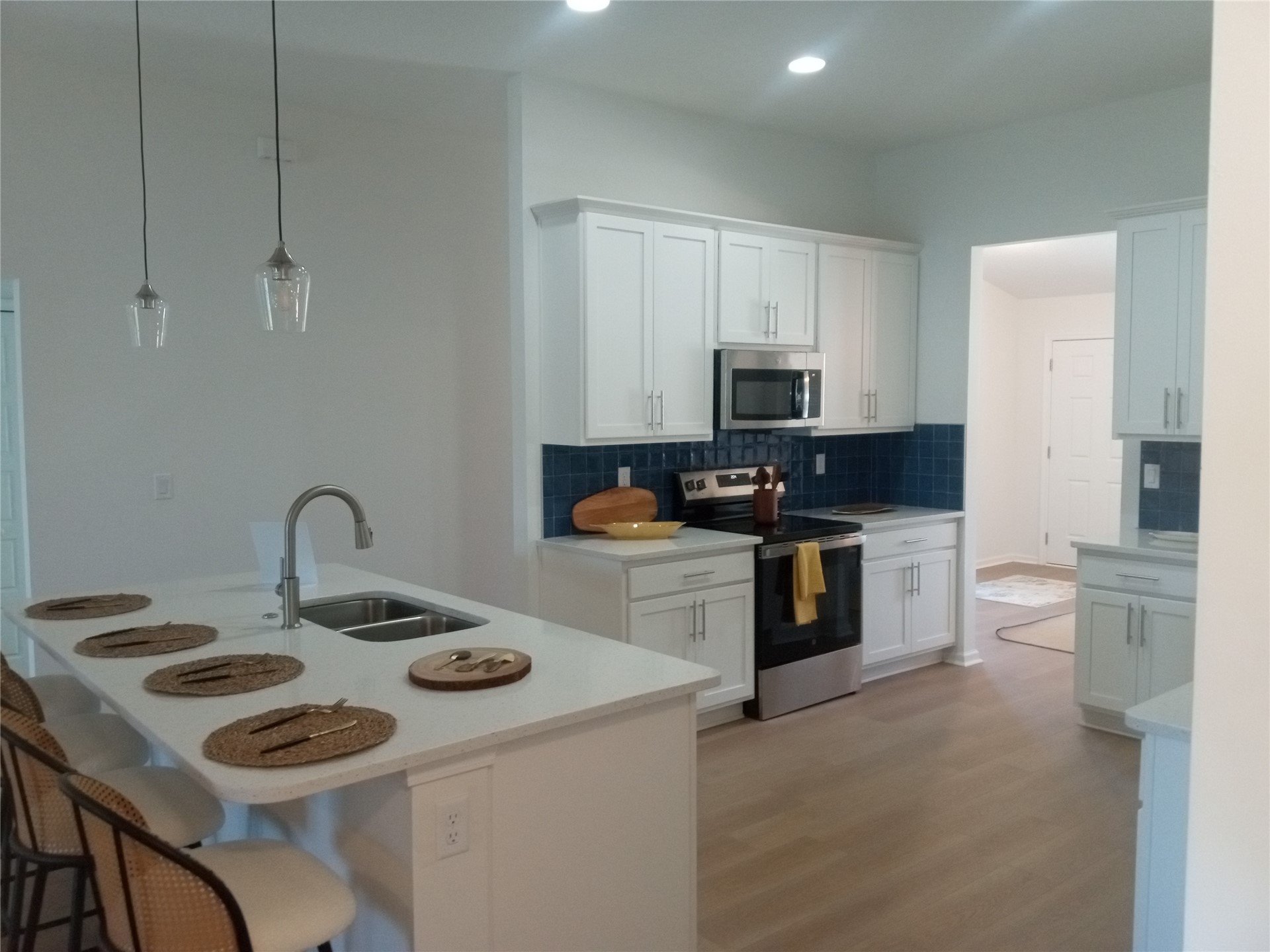 96052 Pirates Bluff Road Yulee, FL 32097 - Photo 10 of 22 a kitchen with a sink a stove and white cabinets