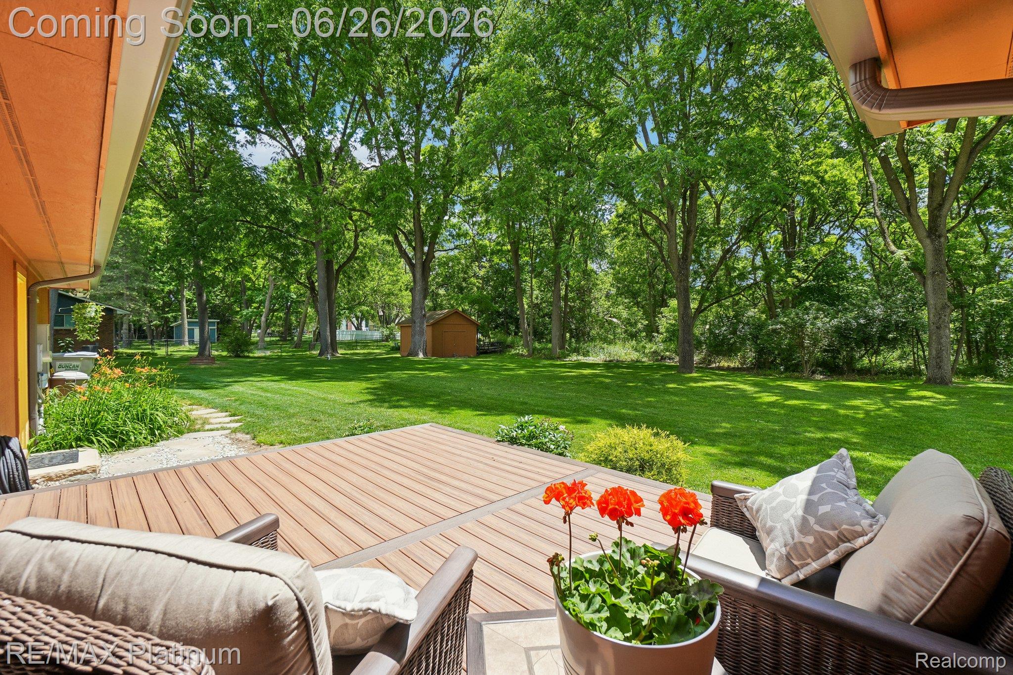 6100 Oak Valley Road Brighton, MI 48116 - Photo 30 of 47 Spacious outdoor deck with composite wood-look flooring overlooking a manicured lawn