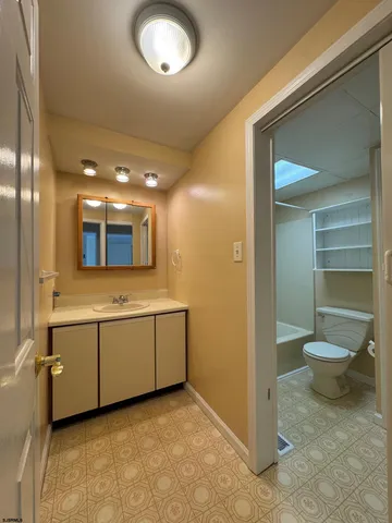 a bathroom with a toilet sink and mirror