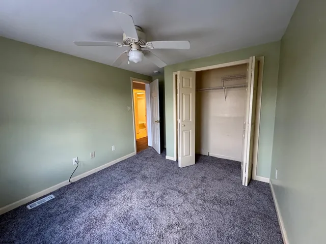 a view of an empty room and a ceiling fan