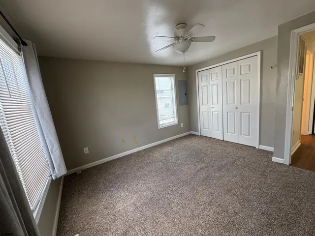 a view of a livingroom with a ceiling fan and window
