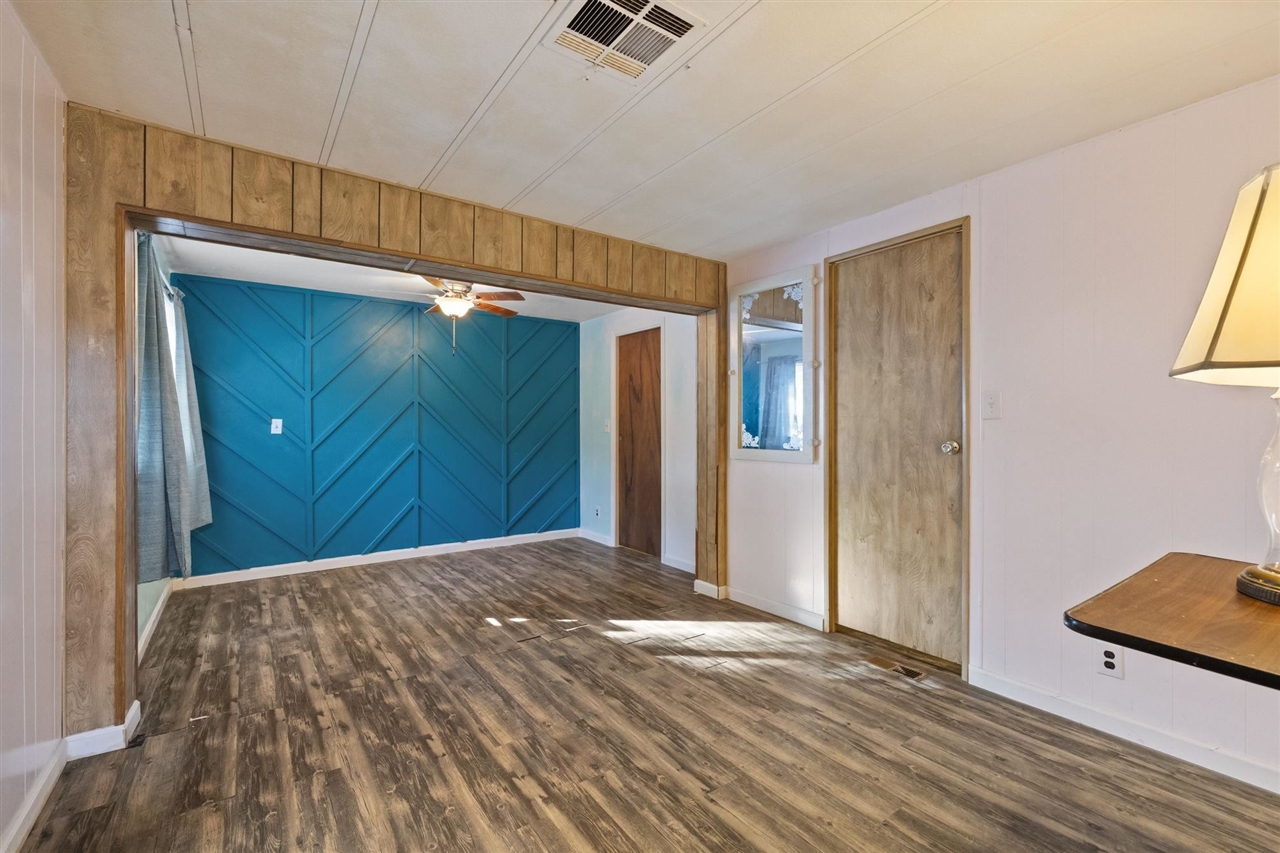 10956 Green Street, Unit 122 Columbia, CA 95310 - Photo 12 of 22 Interior space with a barn door, ceiling fan, wooden walls, and dark hardwood / wood-style flooring