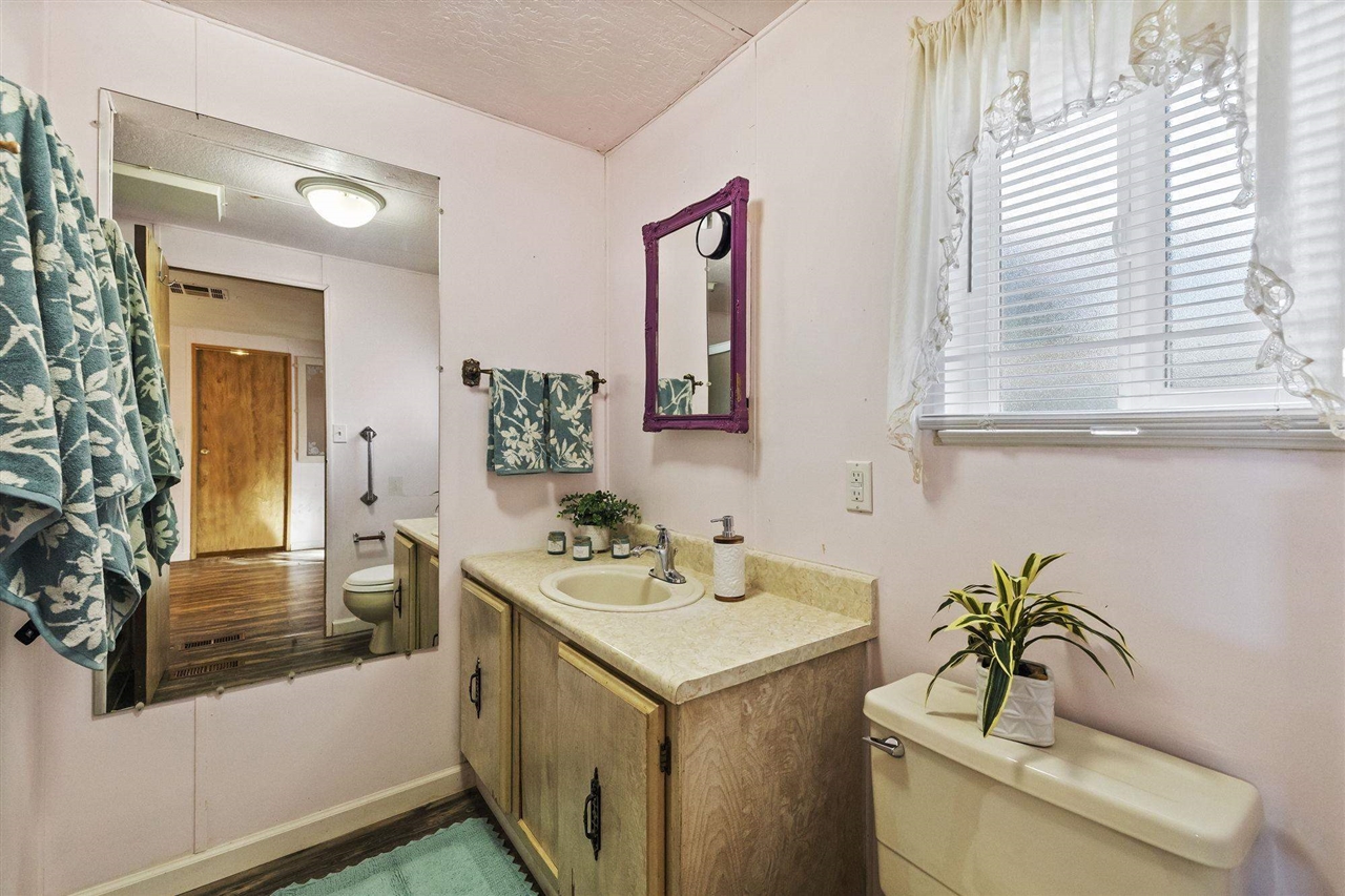 10956 Green Street, Unit 122 Columbia, CA 95310 - Photo 14 of 22 Bathroom with toilet, vanity, wood-type flooring, and a textured ceiling