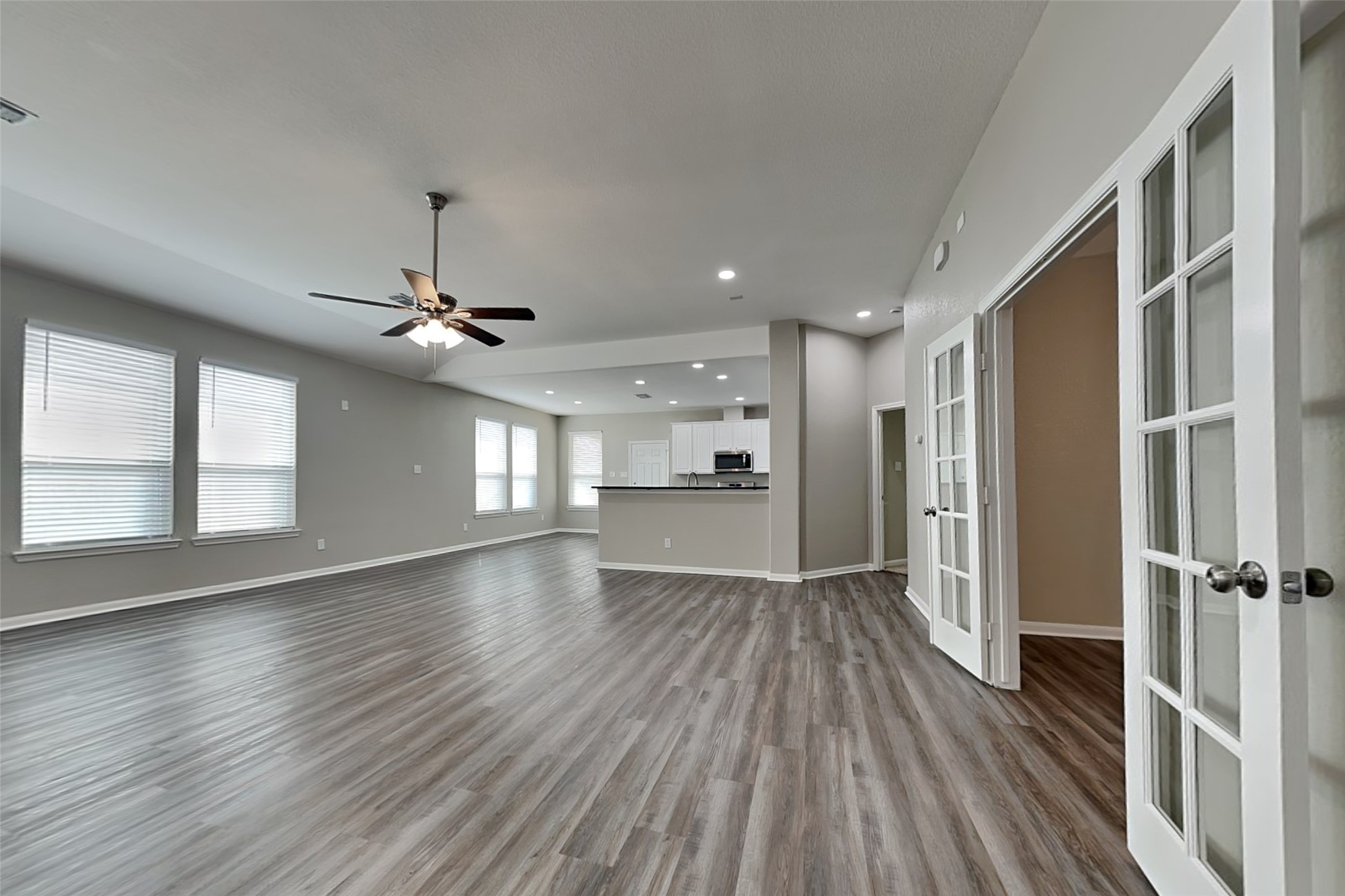 9435 Edgeloch Drive Spring, TX 77379 - Photo 3 of 18 an empty room with wooden floor a ceiling fan and windows