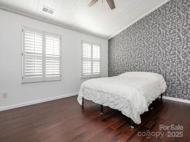 a bed sitting in a bedroom next to a window