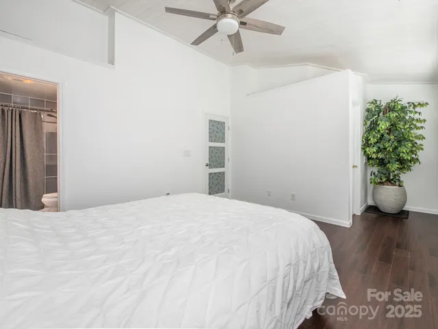 a bedroom with a bed and a potted plant