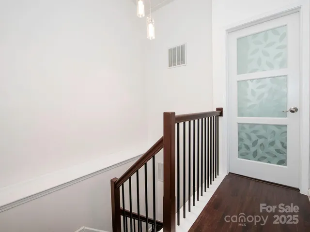 a view of a hallway with wooden floor and a window