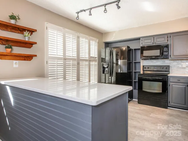 a kitchen with stainless steel appliances kitchen island granite countertop a sink and a stove