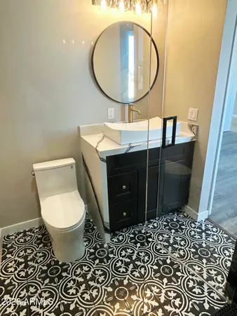 a bathroom with a toilet mirror and vanity