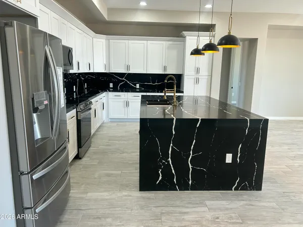 a kitchen with stainless steel appliances granite countertop a refrigerator and a sink