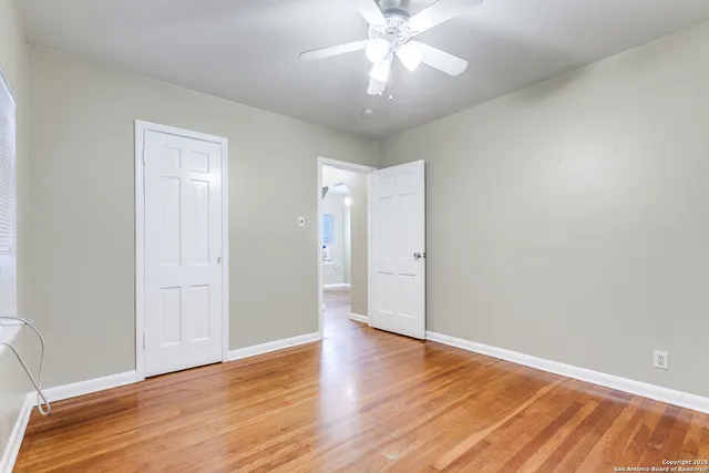 a view of an empty room with wooden floor