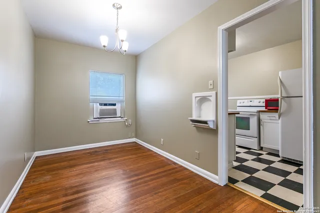 a very nice looking room with wooden floor and ceiling fan