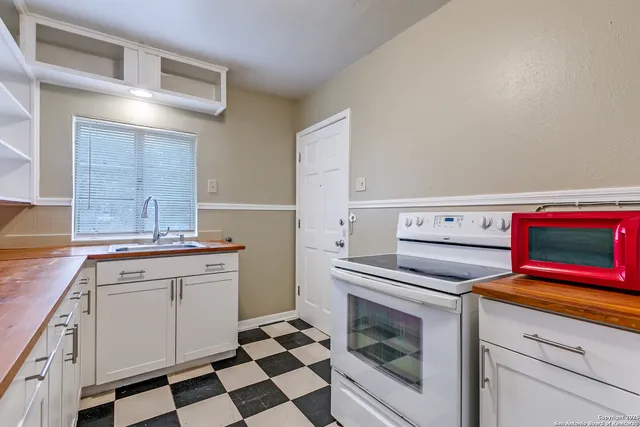 a kitchen with white cabinets and appliances