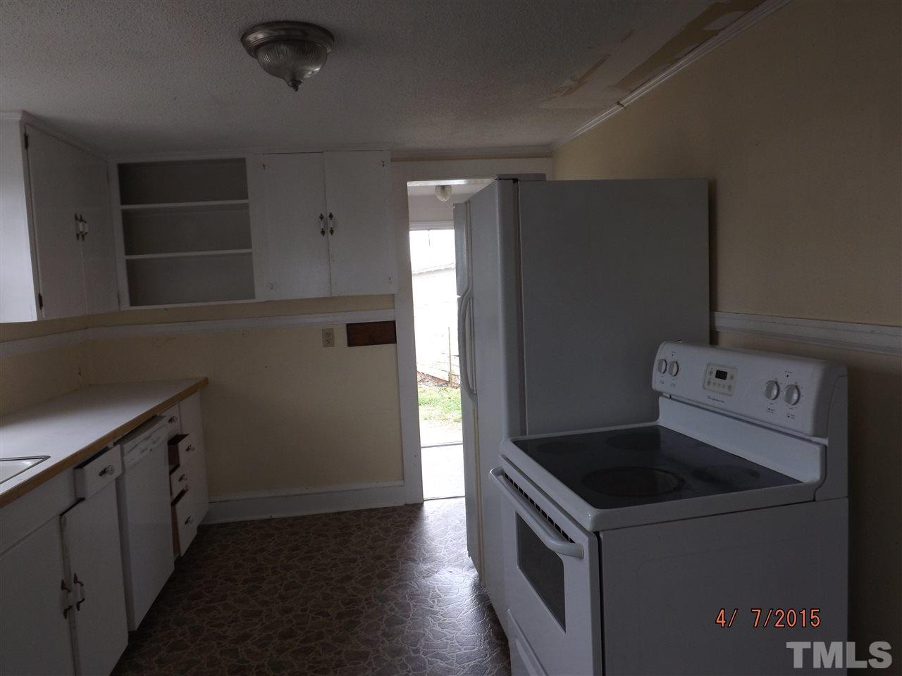 6119 Foushee Road Ramseur, NC 27316 - Photo 6 of 16 a kitchen with a stove and white cabinets