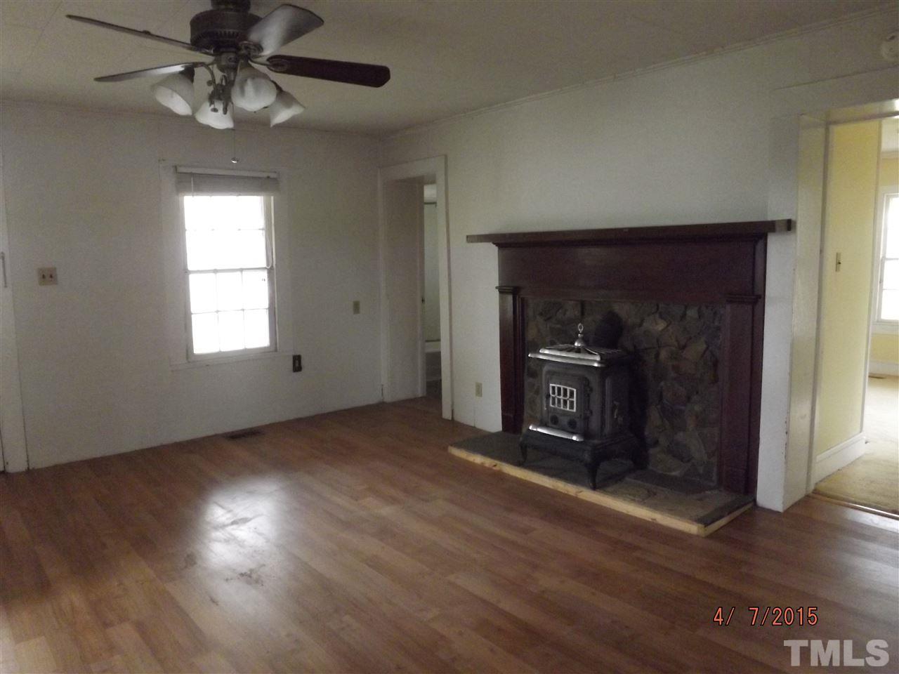 6119 Foushee Road Ramseur, NC 27316 - Photo 7 of 16 an empty room with wooden floor chandelier fan and windows