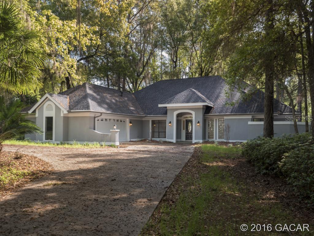 4417 Southwest 84 Way Gainesville, FL 32608 - Photo 1 of 1 a front view of house with yard and trees around