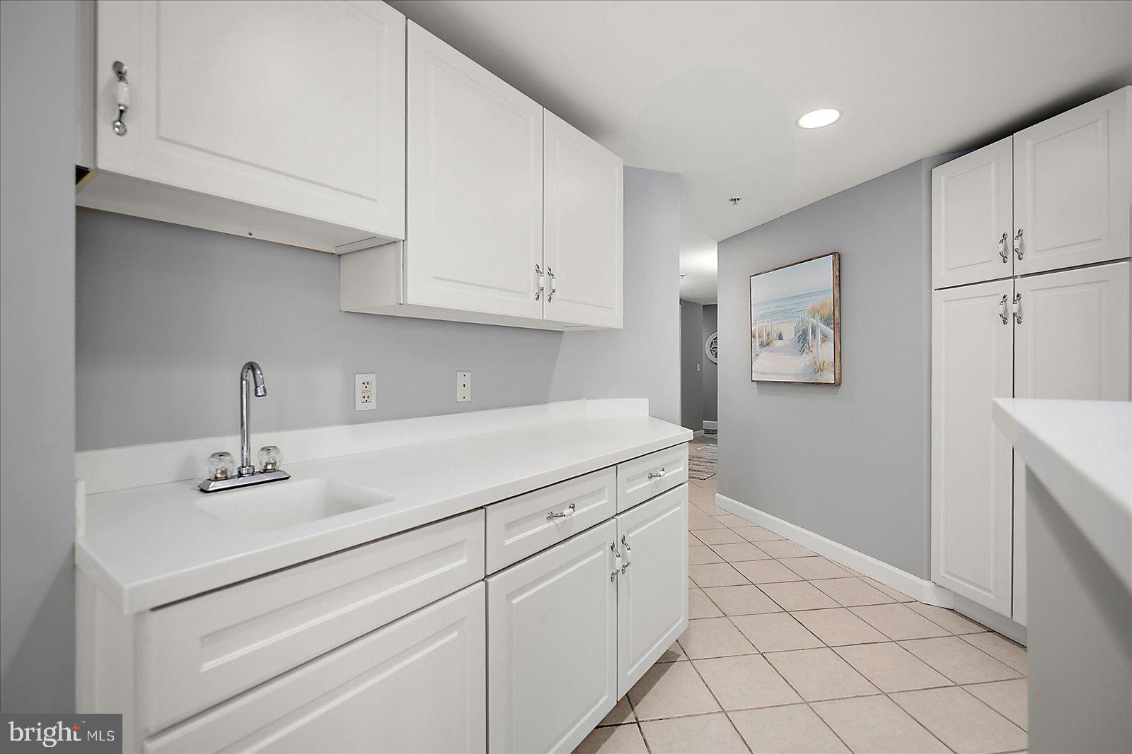 5300 Coastal Highway, Unit 101 Ocean City, MD 21842 - Photo 17 of 85 a kitchen with white cabinets and white appliances