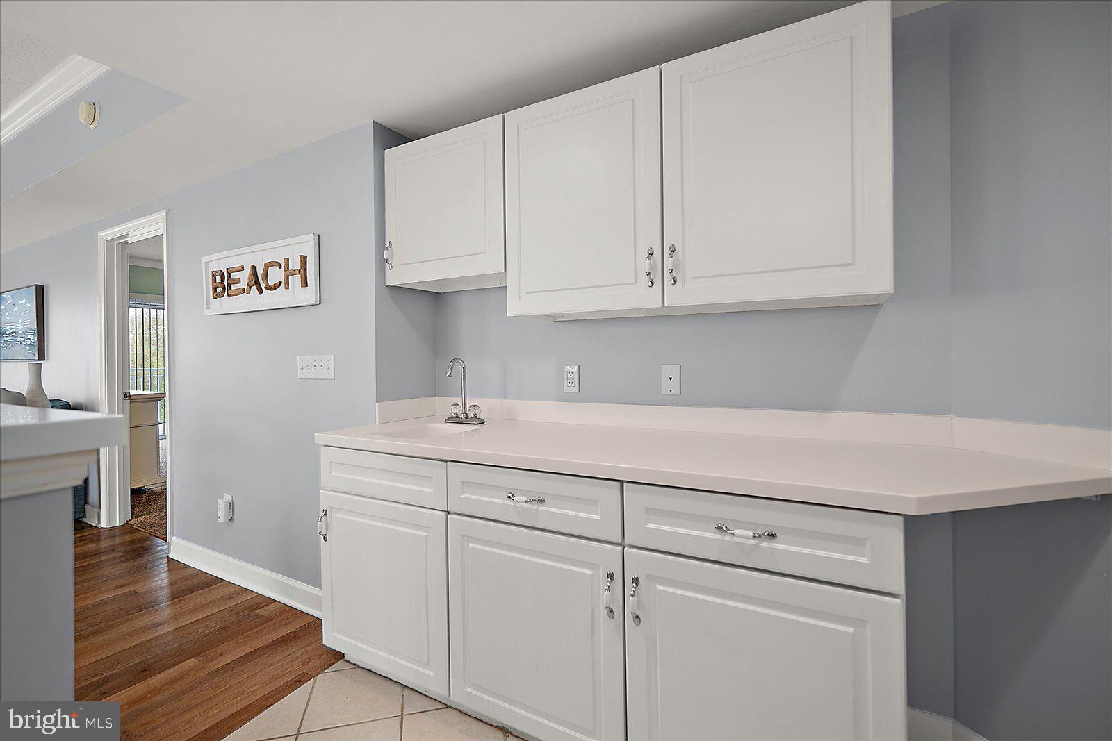 5300 Coastal Highway, Unit 101 Ocean City, MD 21842 - Photo 18 of 85 a room with cabinets and wooden floor