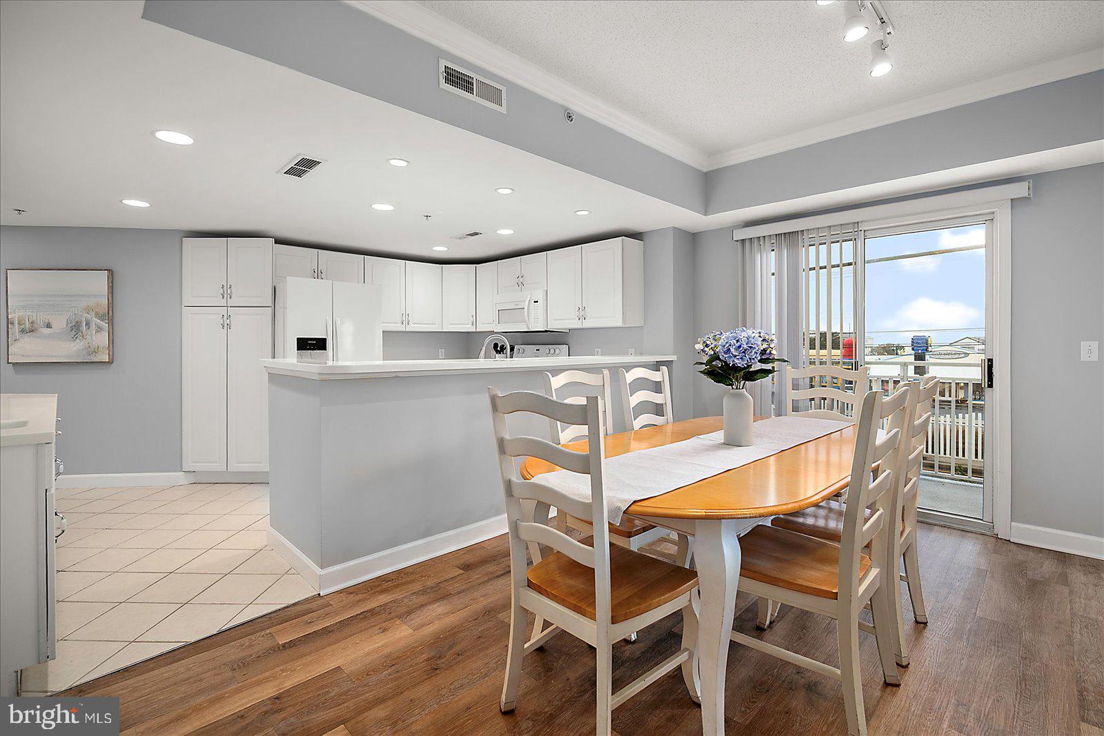 5300 Coastal Highway, Unit 101 Ocean City, MD 21842 - Photo 24 of 85 a kitchen with stainless steel appliances granite countertop a stove a refrigerator a microwave oven with a dining table and chairs
