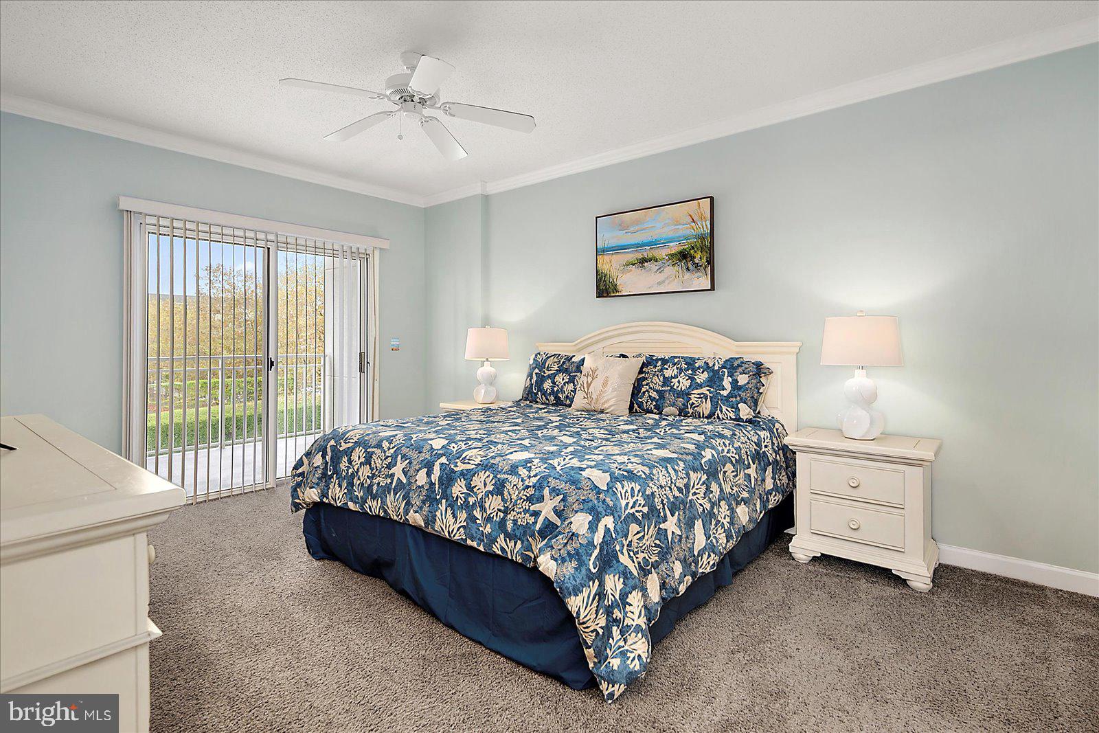 5300 Coastal Highway, Unit 101 Ocean City, MD 21842 - Photo 26 of 85 a bedroom with a bed and a chandelier