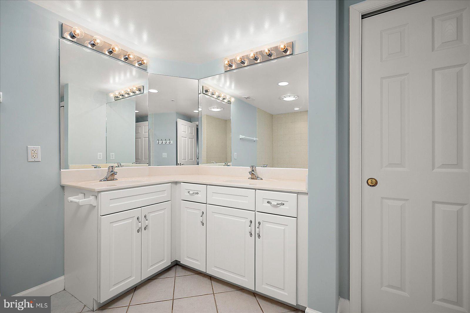 5300 Coastal Highway, Unit 101 Ocean City, MD 21842 - Photo 29 of 85 a spacious bathroom with a double vanity sink a mirror and a shower