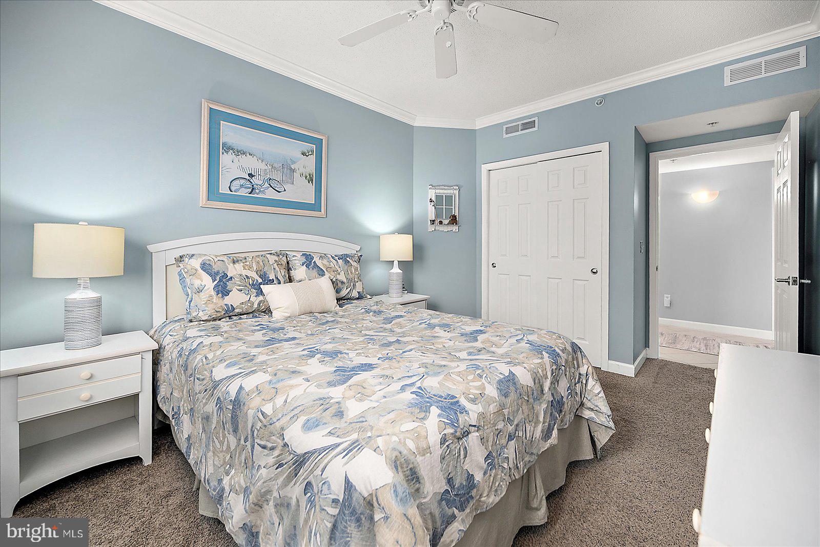 5300 Coastal Highway, Unit 101 Ocean City, MD 21842 - Photo 35 of 85 a bedroom with a bed and a chandelier
