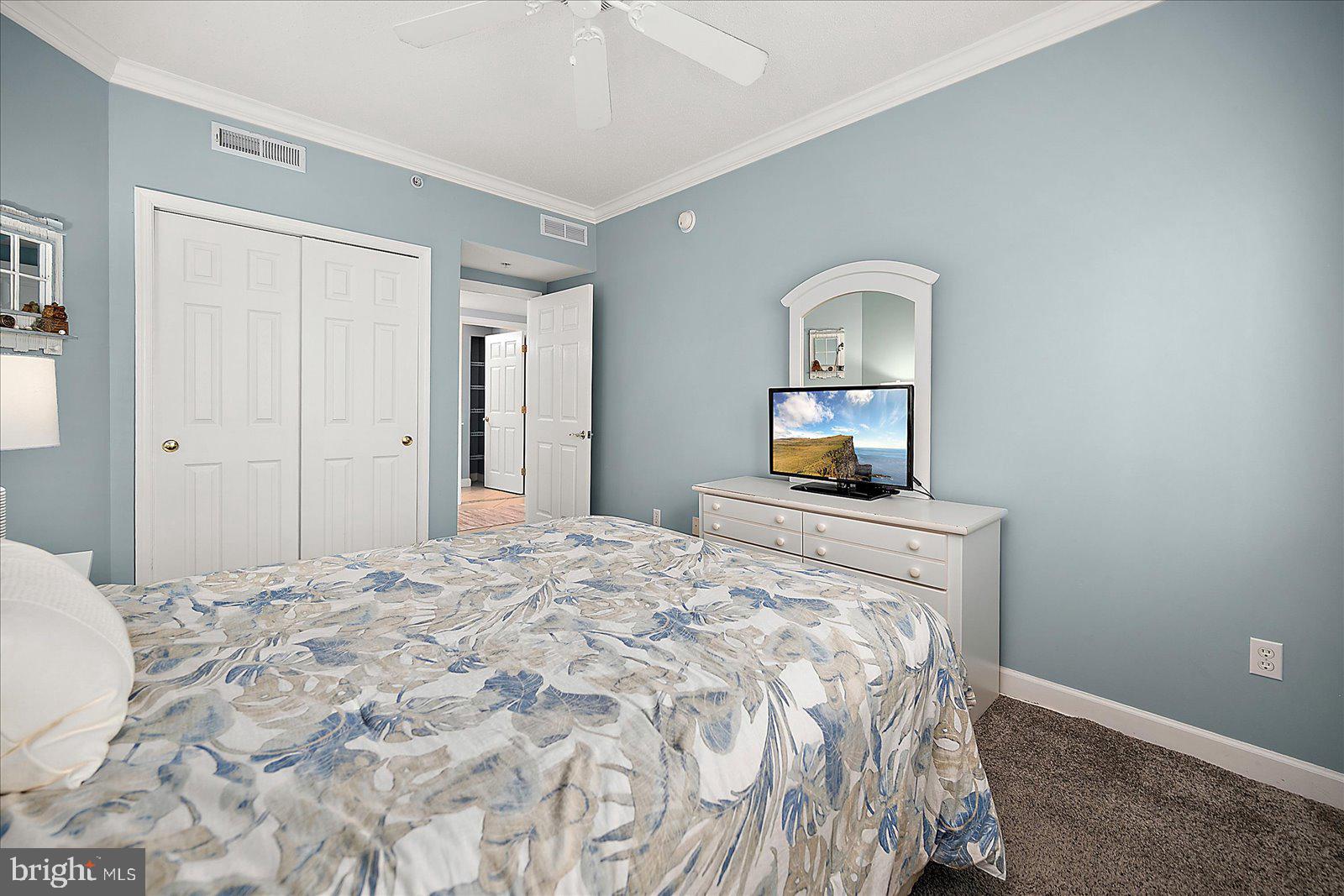 5300 Coastal Highway, Unit 101 Ocean City, MD 21842 - Photo 36 of 85 a bedroom with a bed and a mirror on dresser