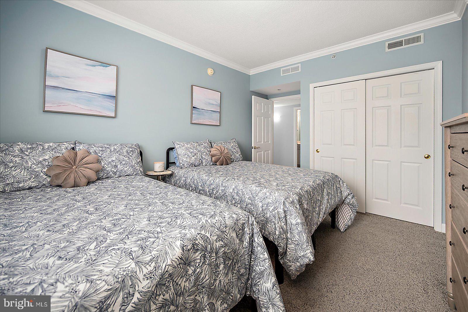 5300 Coastal Highway, Unit 101 Ocean City, MD 21842 - Photo 38 of 85 a spacious bedroom with two bed and a window