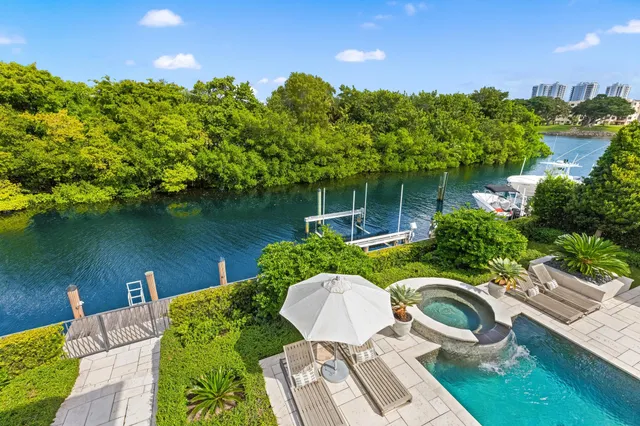 a backyard of a house with table and chairs plants and large tree