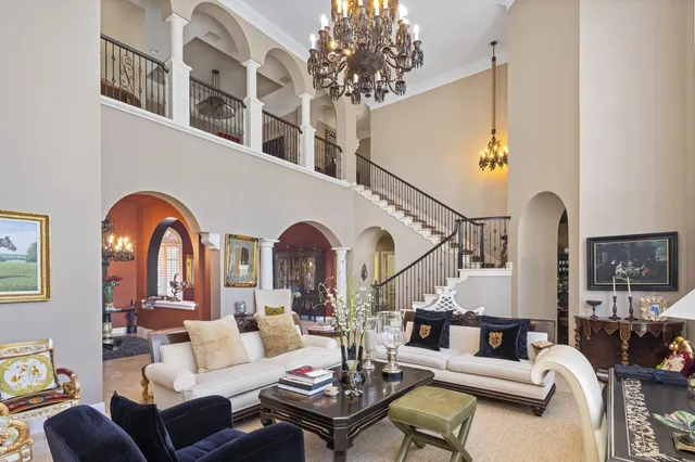 a living room with furniture a chandelier and a rug