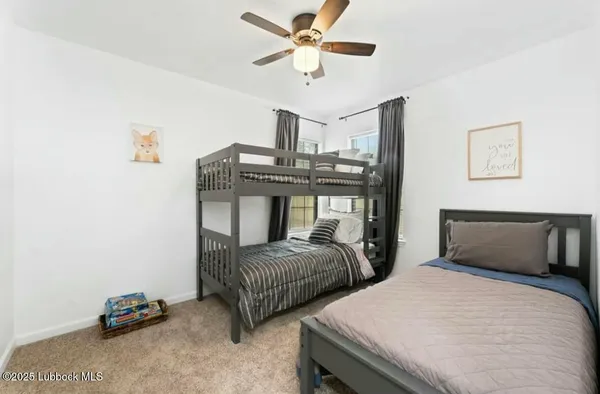 a bedroom with two beds and a ceiling fan