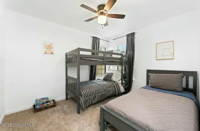 a bedroom with two beds and a ceiling fan